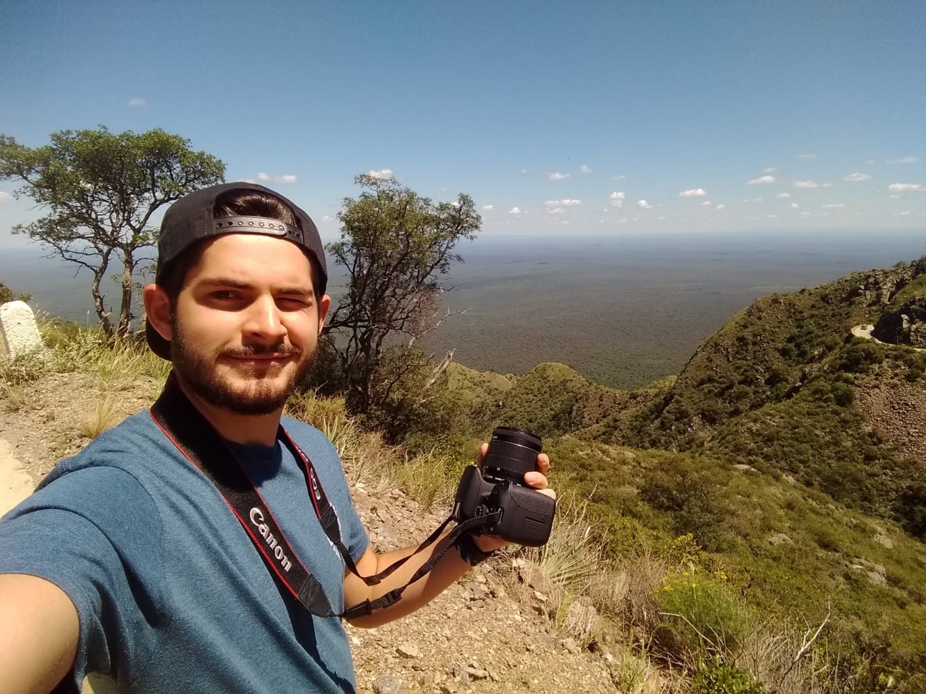 Franco sujentando una cámara frente a un paisaje